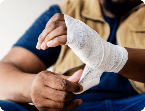 Person wrapping a wound on their wrist with gauze.