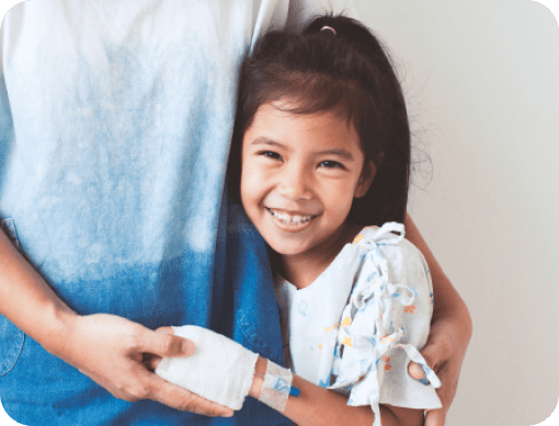 Young girl hugging adult with IV in arm